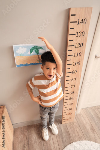 Little Asian boy measuring ...