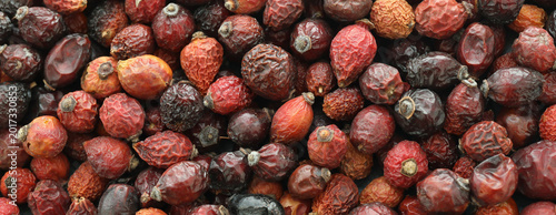 Rose hips dried fruits on table close up. Large amount of red rose hips