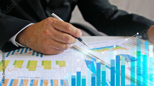 Businessman reviewing balance sheet and virtual data charts. financial analysis concept, strategy planning and growth opportunities, calculating company investment