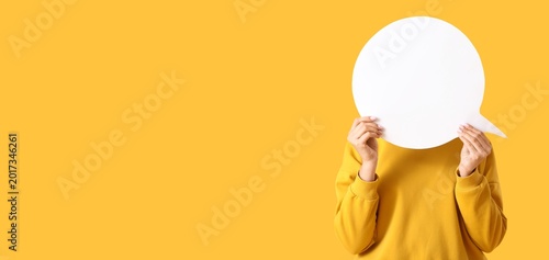 Photos Young woman holding blank speech bubble on yellow background with space for text