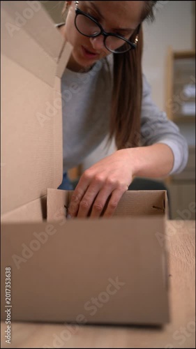 Close-up of a female entrepreneur small business owner assembling cardboard boxes to ship orders