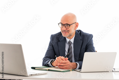 Confident businessman sitting at isolated background and using laptop