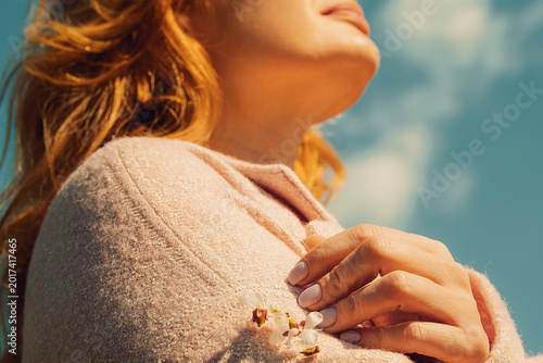 Canvastavla Woman enjoys warm sunlight while standing in  blooming cherry during springtime in rural area with trees and flowers