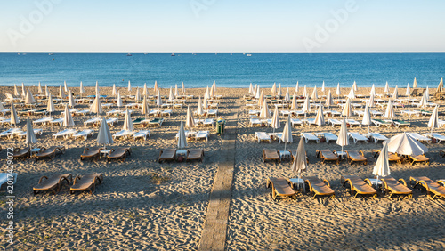 Fotografie Rows of Empty Sunbeds and Closed Umbrellas on the Beach in Alanya Turkey