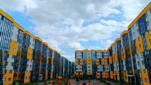 Colorful apartment complex with landscaped surroundings. Energetic scene showcasing multilevel housing with garden features