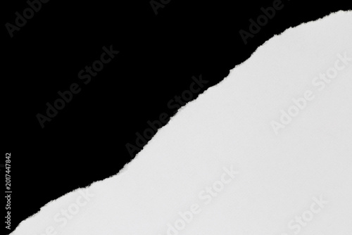 torned piece of white paper against black background