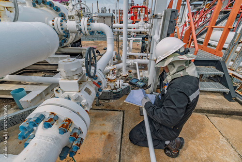 Male worker inspection and measurement thickness pipeline oil and gas at check record pipeline