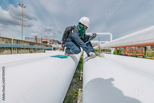 Male worker inspection and measurement thickness pipeline oil and gas at check record pipeline
