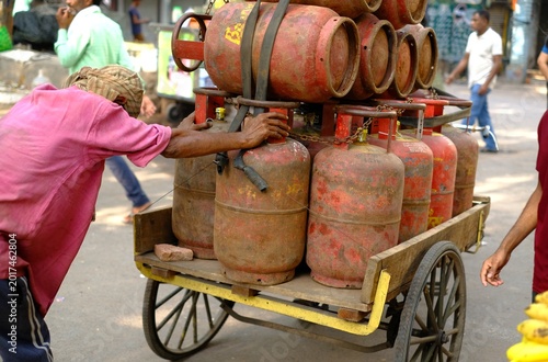 Delhi India 2026: Fully loaded rickshaw with LPG cylinders gas for distribution.