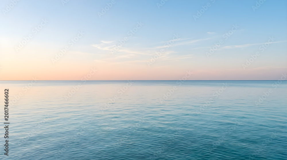 Obraz premium A serene and peaceful view of a calm ocean under a soft pastel sunset sky with gentle ripples on the water surface.