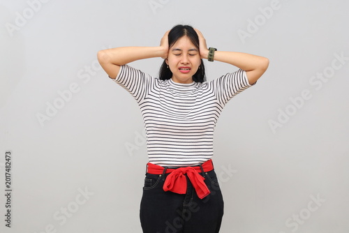 Photography A stressed and panicked woman, confused not knowing what to do, screaming while holding her head and looking at the camera with a worried face, isolated on a white background