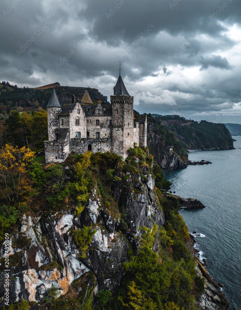 Fototapeta premium Majestic Castle on Cliff Overlooking Serene Ocean and Dramatic Sky