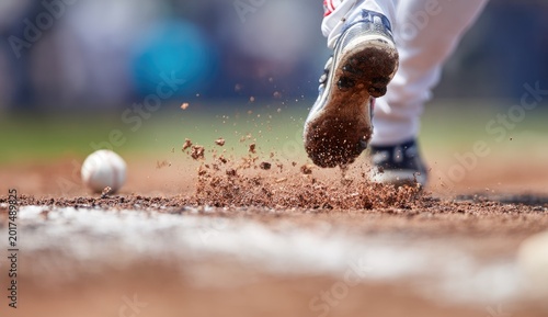 Low angle, player's cleats kicking dirt, baseball near base