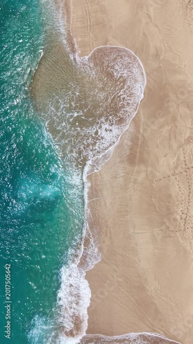 Still shot looking straight down at waves lapping on the beach on the northshore of Oahu in the Hawaiian Islands .