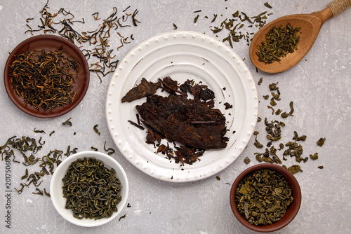 Tableau sur toile tea leaves of different varieties dried and fermented on a gray concrete table w