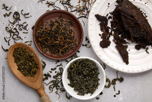 Schilderij op canvas tea leaves of different varieties dried and fermented on a gray concrete table w
