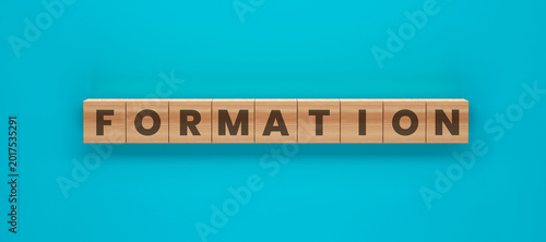 Quadro su tela Formation of Wooden Tiles: Wooden tiles spelling out FORMATION against a vibrant blue background, creating a visual representation of structure and organization