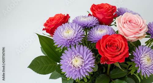 Red roses and purple asters arranged in a bouquet on white background  