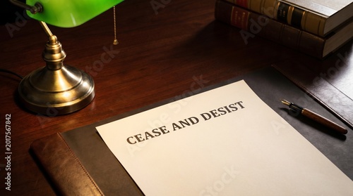 Cease and desist letter on wooden desk with pen and brass lamp