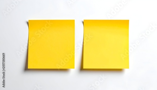 Two square yellow sticky notes affixed to a white surface, seen from above
