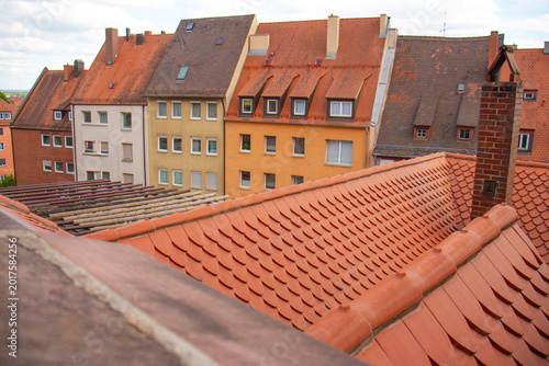 high-angle view overlooking traditional European orange tile rooftops and colorful residential apartment buildings in a historic old town