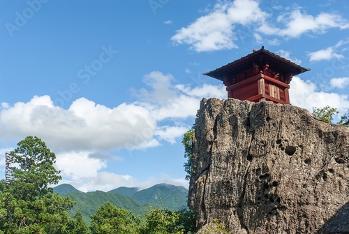 山形市 山寺にある立石寺の断崖絶壁に佇む赤い納経堂と、夏の青空に広がる白い雲の風景/Red Nokyodo Hall Standing on a Steep Precipice Under a Blue Summer Sky in Yamadera