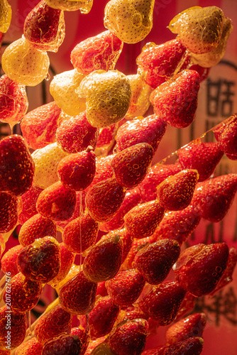 Many skewed red glazed Strawberries to sell at the street market