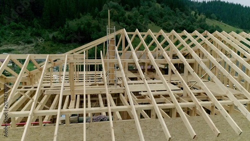 Quadro su tela Aerial drone view of expansive wooden house frame and roof trusses