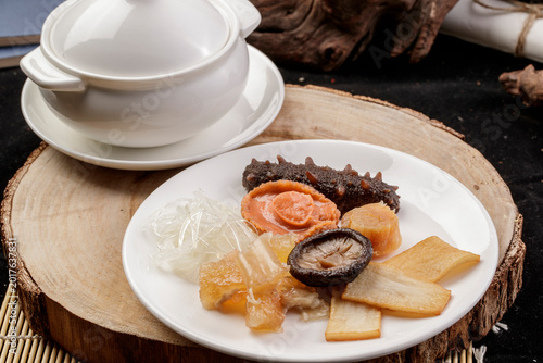 Fotografía The white porcelain tableware on the pine cutting board clattered against the rich seafood soup