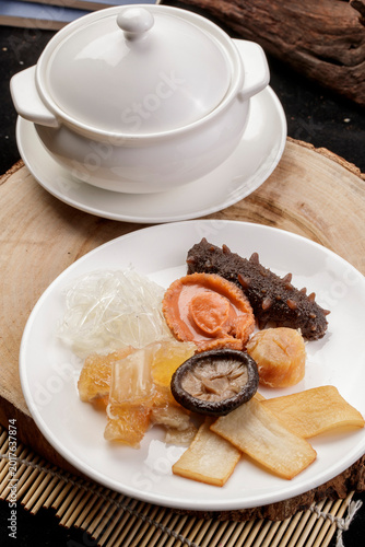 Принти на полотні The white porcelain tableware on the pine cutting board clattered against the rich seafood soup