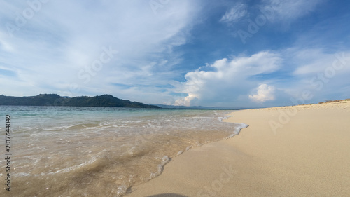 Sandy Beach and Turquoise Water Under Cloudy Sky