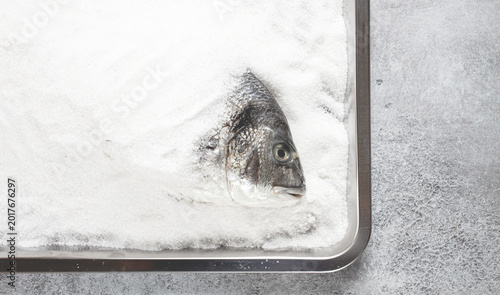 Foto Fresh Dorado fish, cooked in coarse salt, on a tray, top view, close-up, no peop
