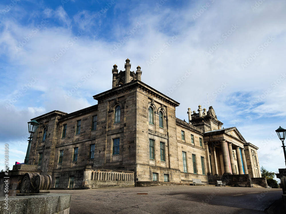 Fototapeta premium Historic neoclassical Modern Two Dean Gallery mansion facade in Edinburgh, Scotland, UK with imposing columns and weathered stone architecture under a dramatic cloudy sky