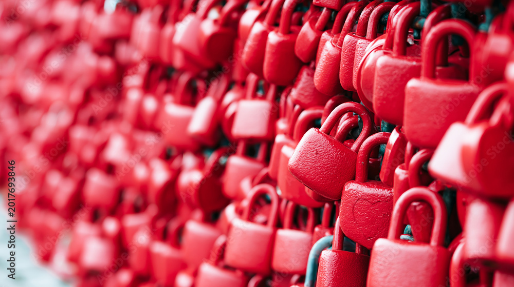 Fototapeta premium Red love padlocks forming a dense texture on a wall, symbolizing lasting love, romance, and unbreakable commitment