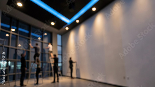 Construction workers installing modern lighting in a contemporary office space