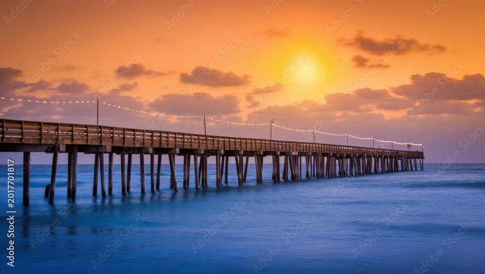 Obraz premium Sunset Over a Wooden Pier