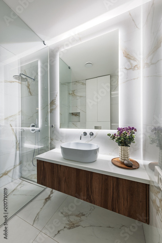 Modern Marble Bathroom Interior With Floating Vanity, Backlit Mirror and Glass Shower Stall