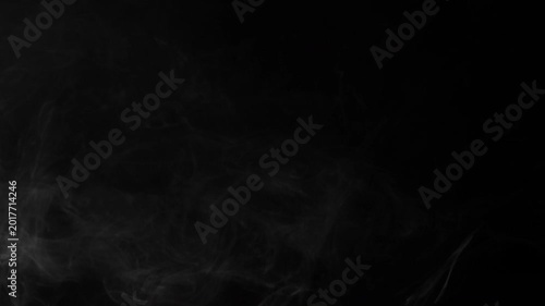 Ethereal white smoke gently drifting and swirling against a dark black background creating an atmospheric effect.