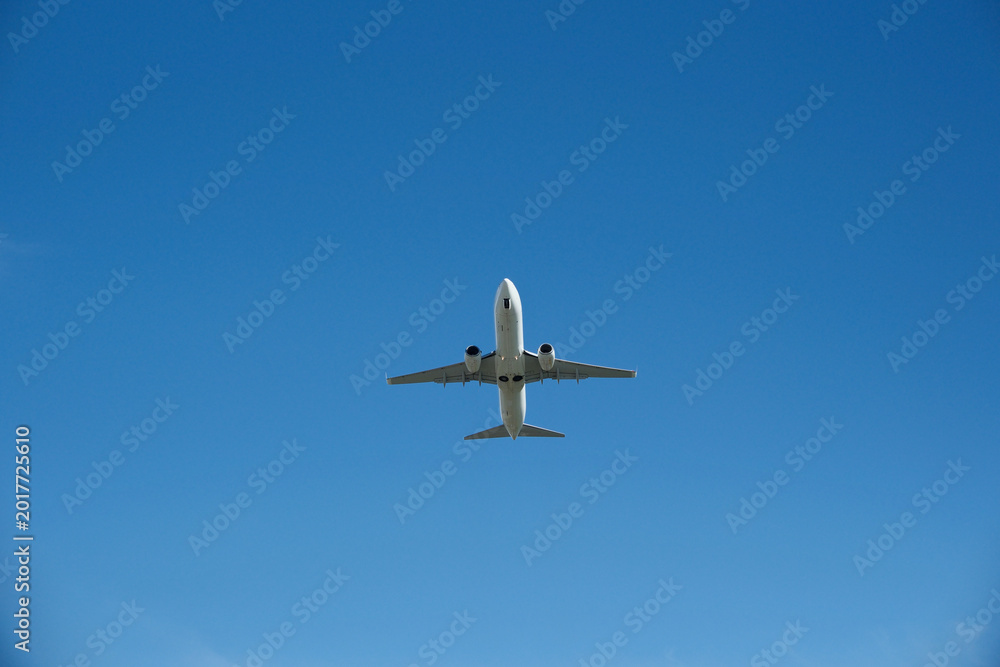 Fototapeta premium White Airplane Taking Off into Clear Blue Sky, Low Angle View