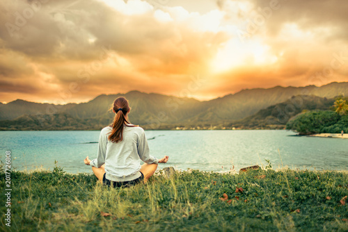 фотографія Woman Meditating By Tropical Ocean At Sunset In Hawaii Wellness, Mindfulness, An