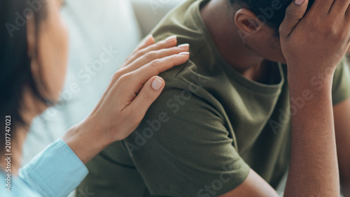Φωτογραφία A person comforts another who looks upset while sitting together in a cozy setting