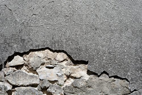 cracked concrete wall background with stones under the brocken surface