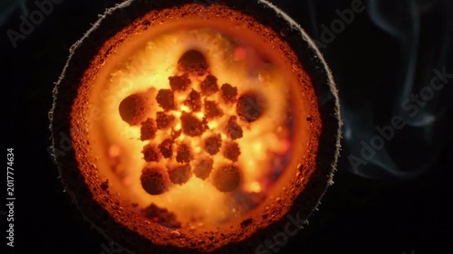 Close up view of glowing molten metal with sparks and smoke, abstract fiery orange texture, heat and energy, industrial process