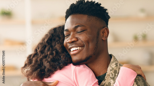 Canvas Print A soldier hugs a family member in a home