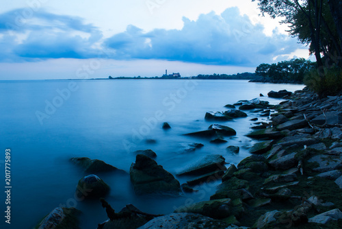 Photography Toronto lakeshore at blue hour with calm water and rocky shoreline