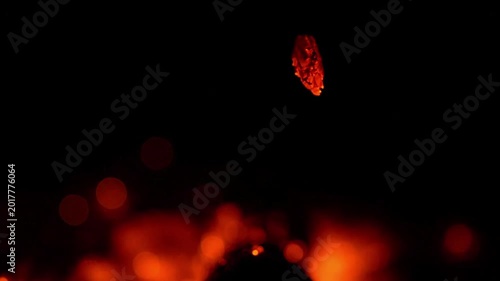 Fiery embers rising from glowing coals, dark background with bokeh lights, abstract representation of heat and energy