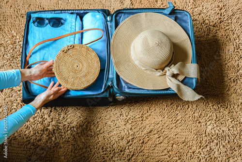 Foto Female preparing suitcase top view