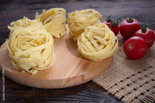 Pasta, tomatoes and mint lie on a wooden table