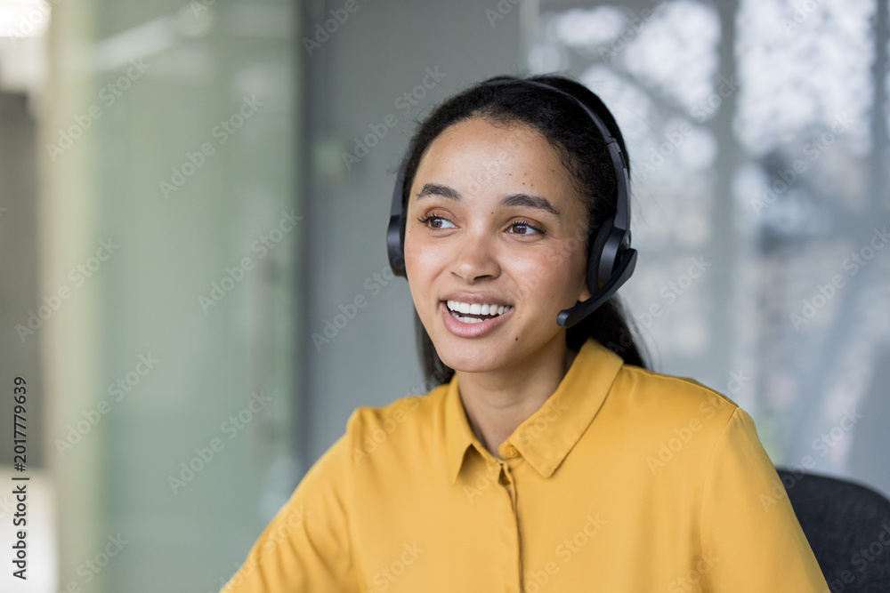 Obraz premium Smiling female call center agent providing customer support
