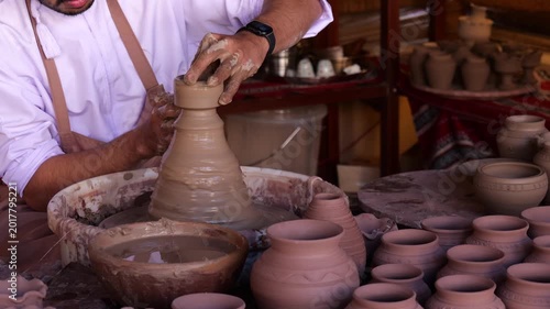Potter molding clay pot on wheel illustrates ancient ceramic craft preserved through manual skill, precision and long standing artisanal techniques